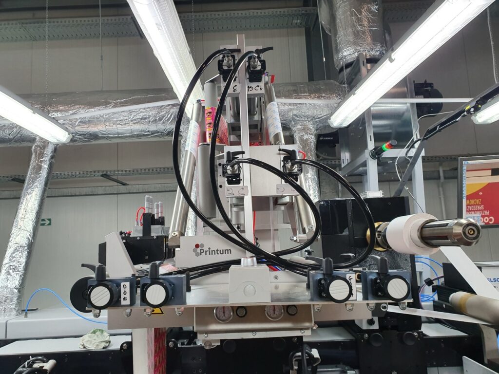 Referenzfoto des Printum Multilayer-Kits – Intergration in einer Anlage: Dank dieses Label Converting Equipments können Sie dank Plug & Play-Technologie sofort mehrlagige Etiketten herstellen, z.B. auf einem Gallus RCS 430 Label Printer ( wie im Bild ) oder anderen üblichen Bestandsmaschinen im Etikettendruck.